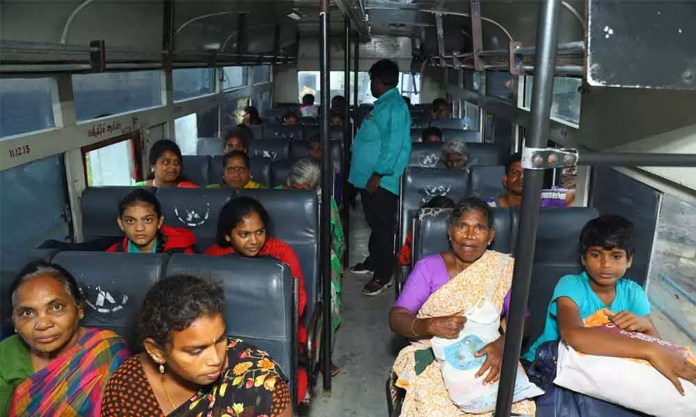 People waiting in a bus arranged by authorities for their evacuation at Kothur