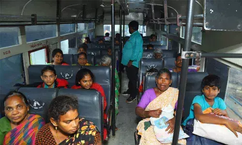 People waiting in a bus arranged by authorities for their evacuation at Kothur