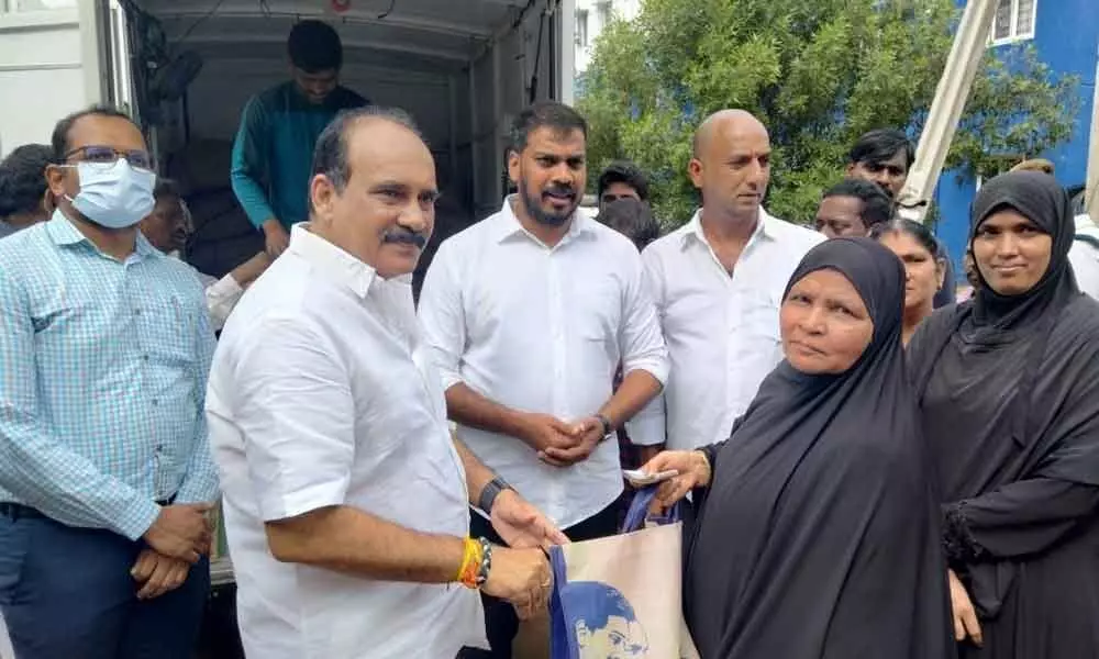 District in-charge Minister B Srinivasa Reddy distributing essential commodities to the flood affected people at Janardhan Reddy Colony in Nellore on Wednesday. Minister Dr Anil Kumar is also seen