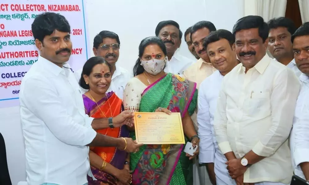 District Collector Narayana Reddy handing over certificate to Kalvakuntla Kavitha in Nizamabad on Friday