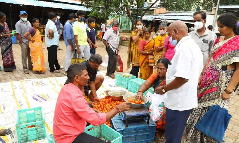 People standing in queue to buy tomatoes at Tirupati Rythu Bazaar on Friday