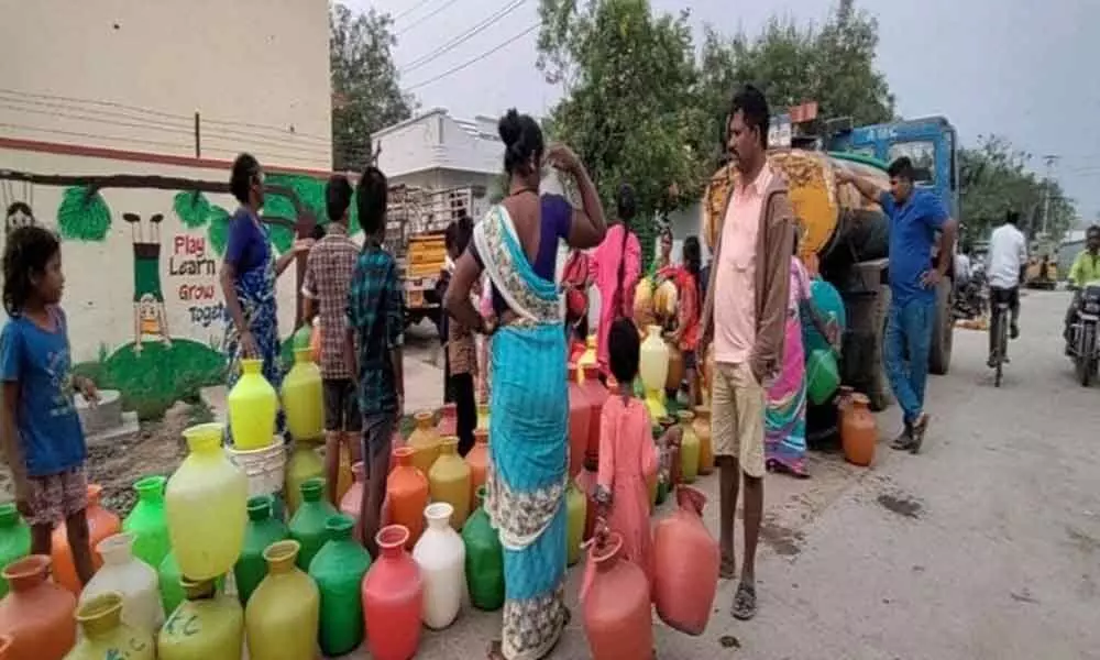 Residents of Kallu Bavi in Adoni town stand in queue at the water tanker to fetch water
