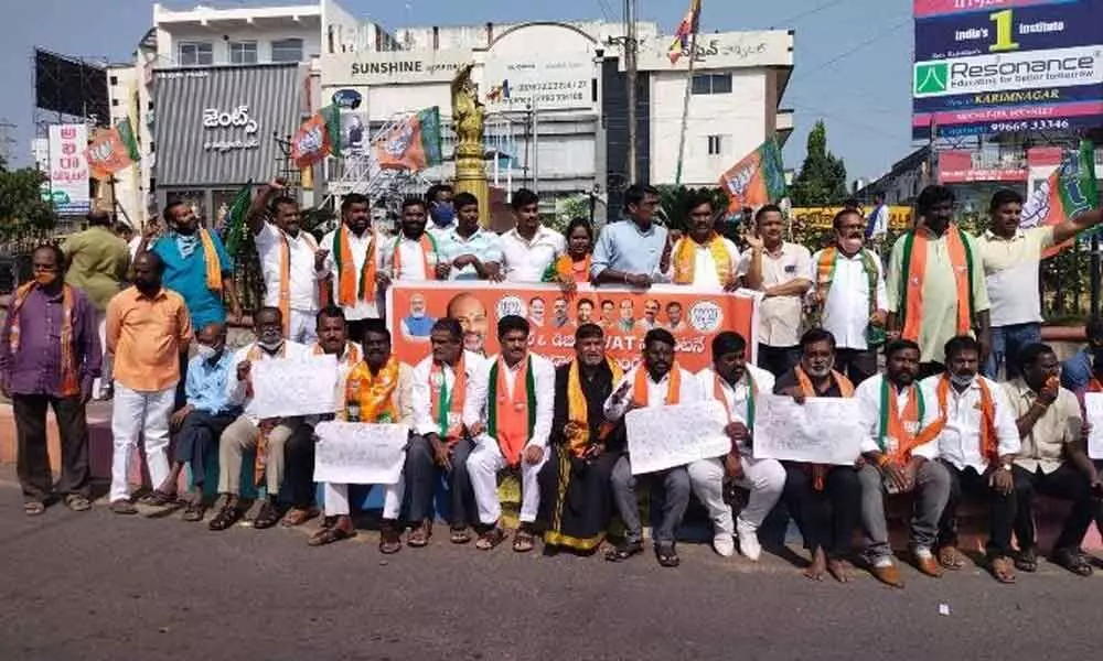 BJP leaders staging a protest demanding the TRS government to reduce VAT on petrol in Karimnagar on Tuesday