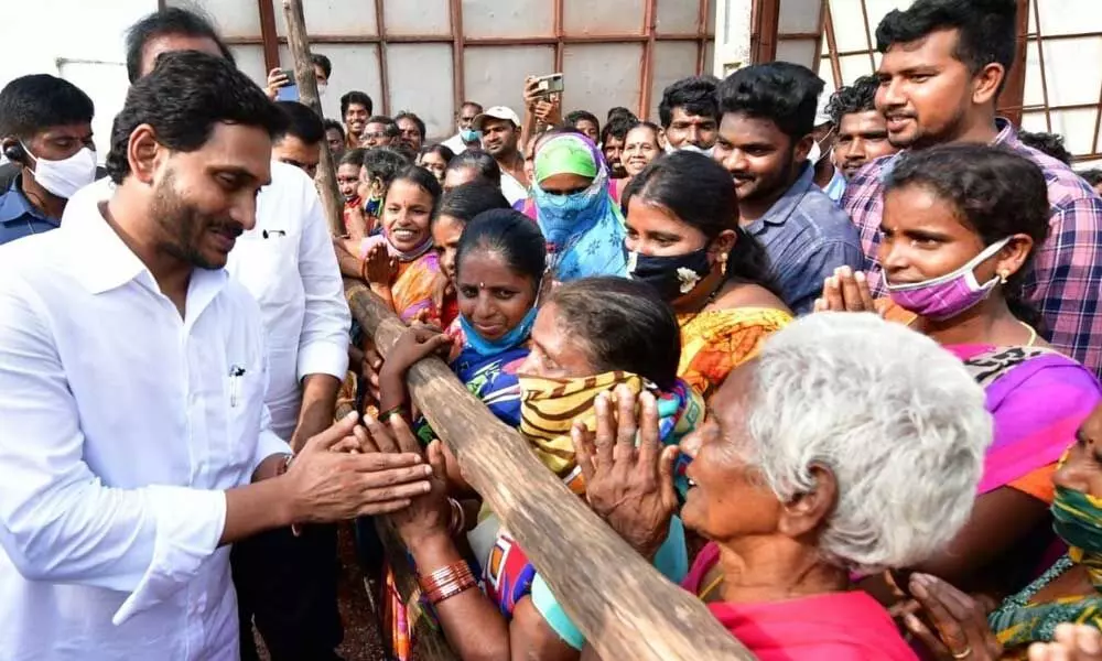 Chief Minister Y S Jagan Mohan Reddy listens to rain victims at Penuballi under Nellore Rural mandal on Friday