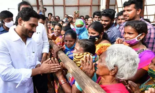 Chief Minister Y S Jagan Mohan Reddy listens to rain victims at Penuballi under Nellore Rural mandal on Friday