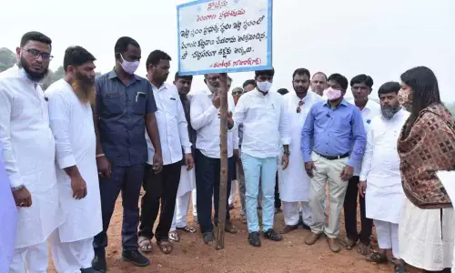 District Collector C Narayana Reddy setting up warning board for the protection of public places in Nizamabad city on Friday