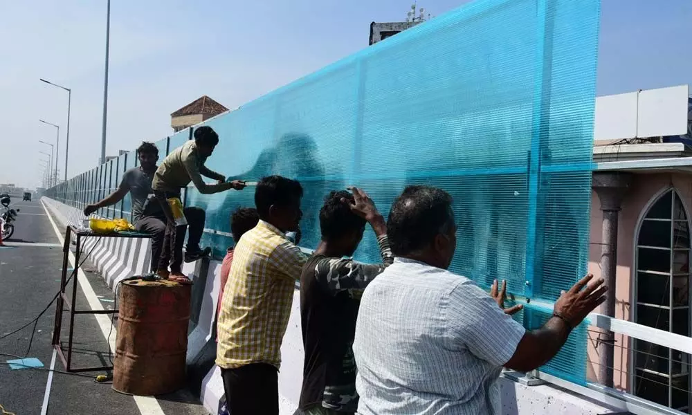 Workers fixing fiber sheet at the new flyover near Benz Circle in Vijayawada on Saturday Photo:  Ch Venkata Mastan