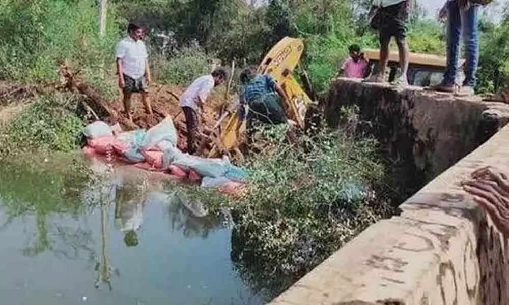 Villagers plugging breaches to a tank in Anantapur