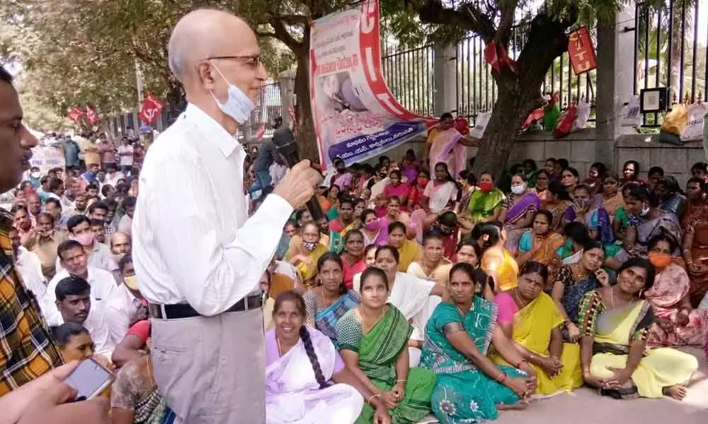 CITU State vice-president Ajay Kumar addressing TTD outsourced workers staging dharna near the TTD administrative building in Tirupati on Tuesday