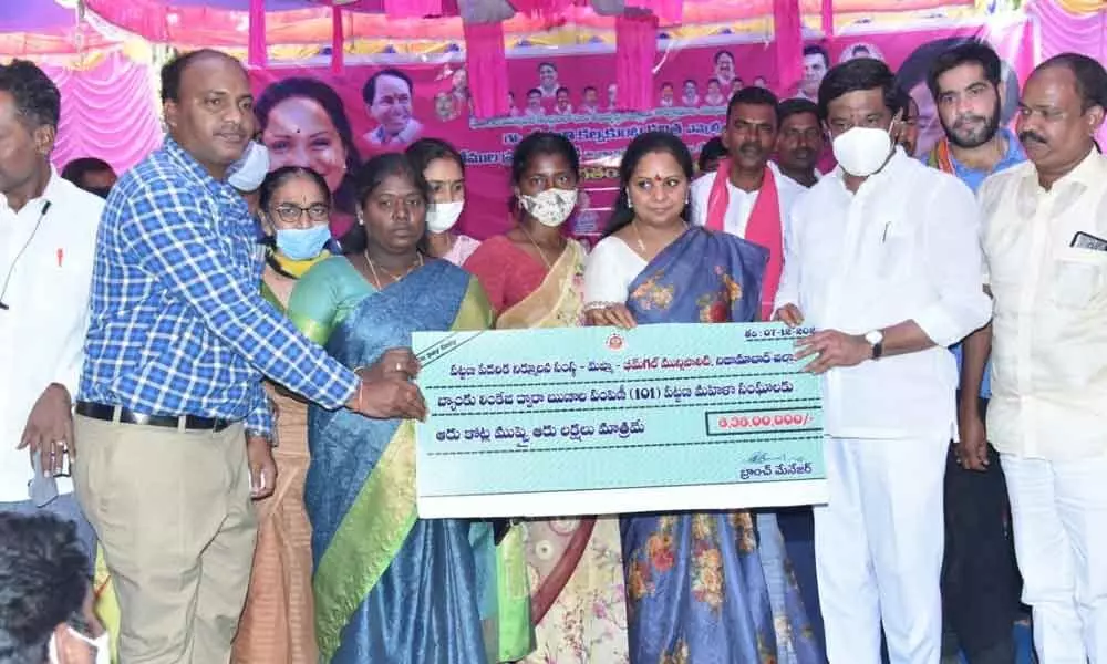 MLC Kavitha and Minister Vemula Prashanth Reddy handing over a cheque of Rs 6.38 crore to Bhimgal women via MEPMA in Bheemgal on Tuesday