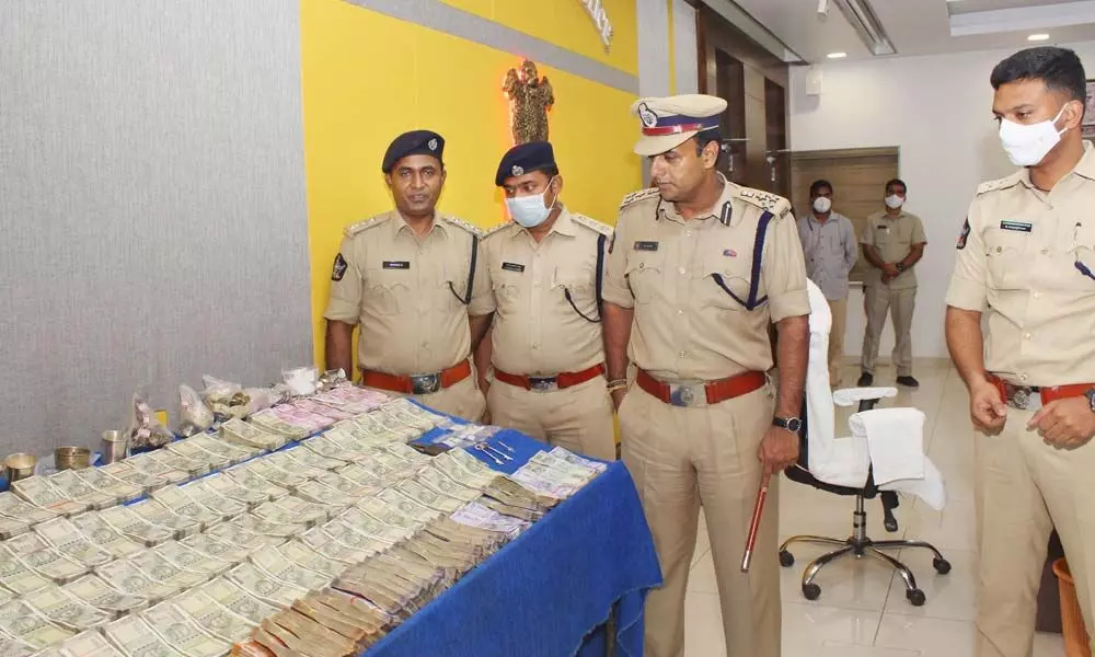 Commissioner of Police Kanthi Rana Tata inspecting the cash and ornaments seized from the accused at the Police Commissionerate in Vijayawada on Saturday