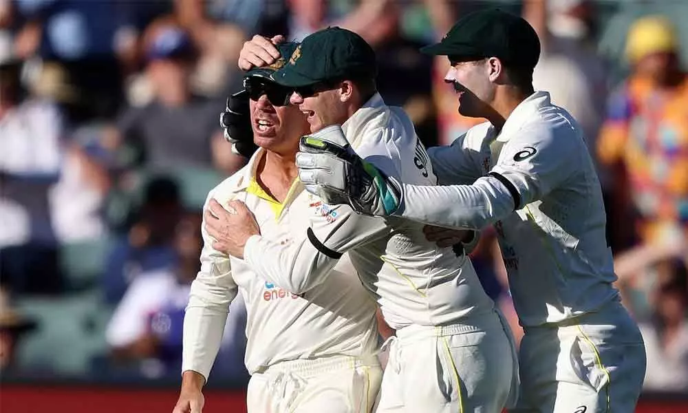 Australias David Warner (left) is congratulated by teammates after catching out Englands Jos Buttler during the third day of the Ashes Test match in Adelaide, Australia on Saturday