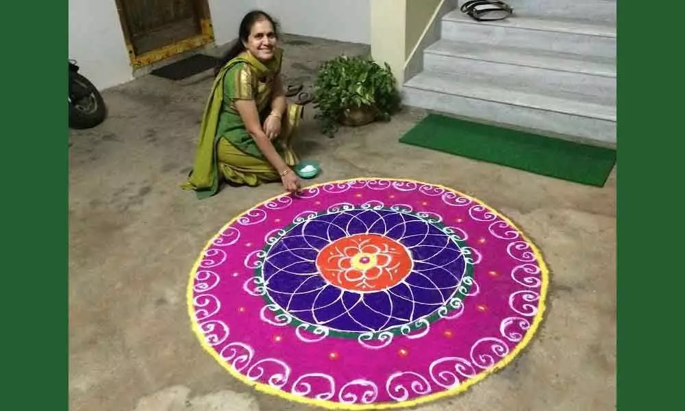 Jyothi Vajjhala giving finishing touches to a rangoli pattern at her home in Visakhapatnam
