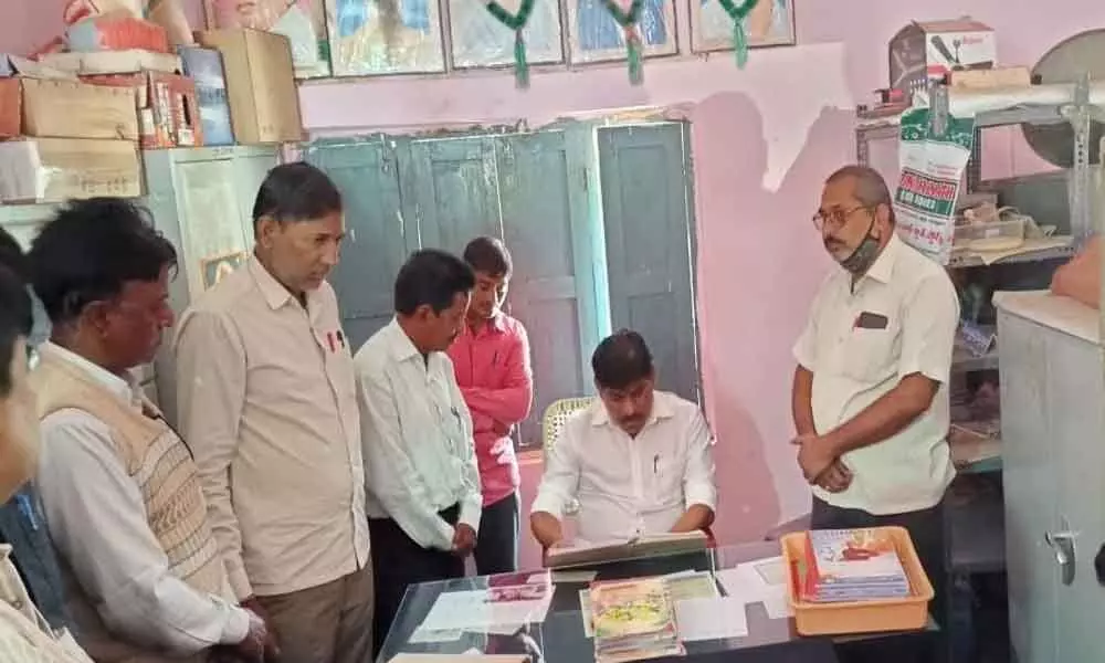 Zaheerabad MP BB Patil checking attendance at a government school in Sirupur village on Monday