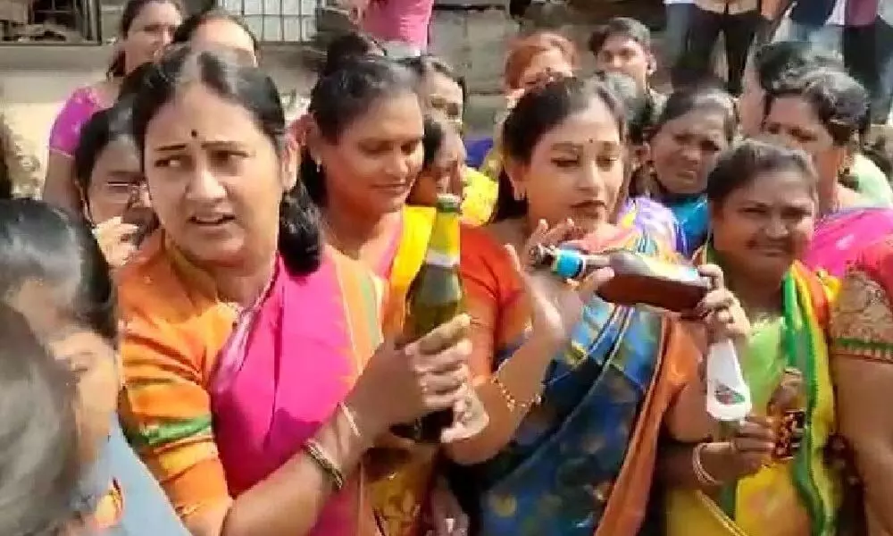 The activists of Telugu Mahila breaking liquor bottles during a protest in Mangalagiri on Tuesday