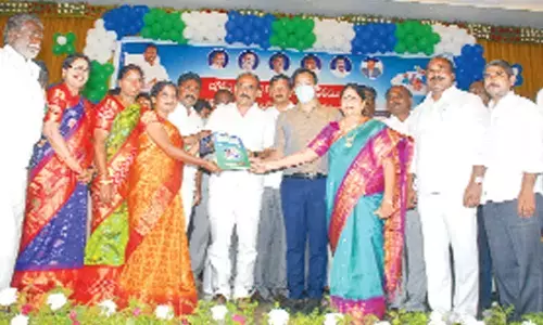 Ministers Balineni Srinivasa Reddy and Audimulapu Suresh, ZP Chairperson Buchepalli Venkayamma and District Collector Pravin Kumar giving house registration documents to a beneficiary in Ongole on Tuesday