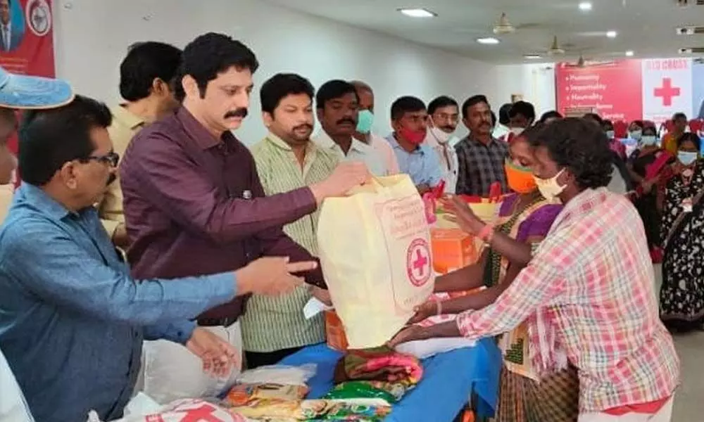 IRCS State Branch Chairman Dr P Sridhar Reddy distributing aid to the villagers of Pallepadu on Saturday