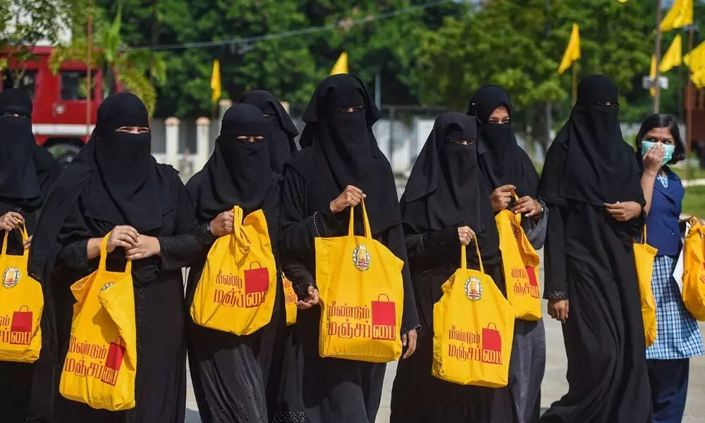 People carry cloth bags after an awareness campaign to Bring Back YellowBag (MeendumManjappai) to curb the use of plastics, during an event inaugurated by Tamil Nadu Chief Minister MK Stalin (unseen), at KalaivanarArangam in Chennai