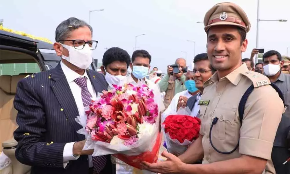 Rural SP Vishal Gunni presenting a bouquet to Supreme Court Chief Justice NV Ramana at Nelapadu in Guntur on Sunday