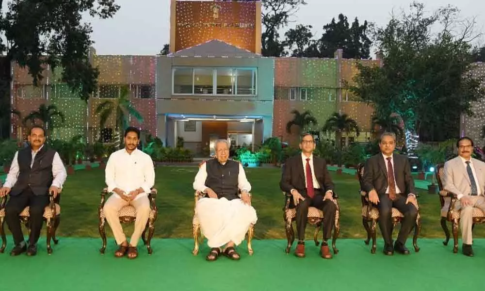 Chief Minister Y S Jagan Mohan Reddy and other dignitaries attend the high tea hosted by Governor Biswa Bhusan Harichandan in honour of CJI N V Ramana at Raj Bhavan in Vijayawada on Sunday