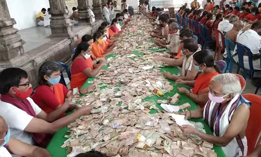 The temple officers and volunteers counting hundis income in Chintrakuta mandapam on the Lord Rama temple premises on Monday in Bhadrachalam on Monday