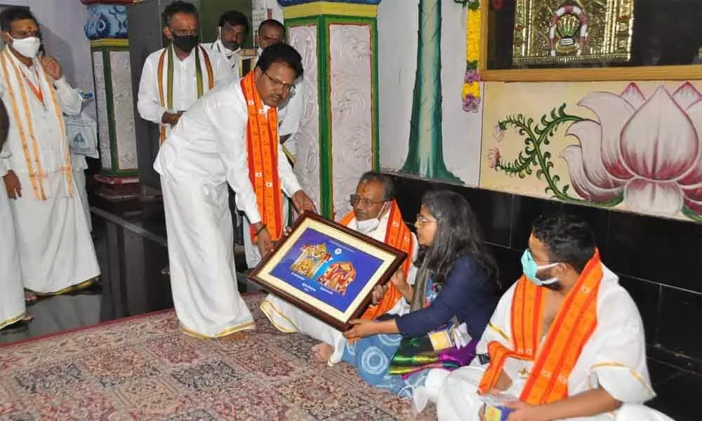 Executive officer S Lavanna presenting a portrait of Lord Mallikarjuna Swamy and Goddess Bhramarambika Devi to Union Rural Development secretary Nagendranath Sinha at Srisailam temple on Wednesday