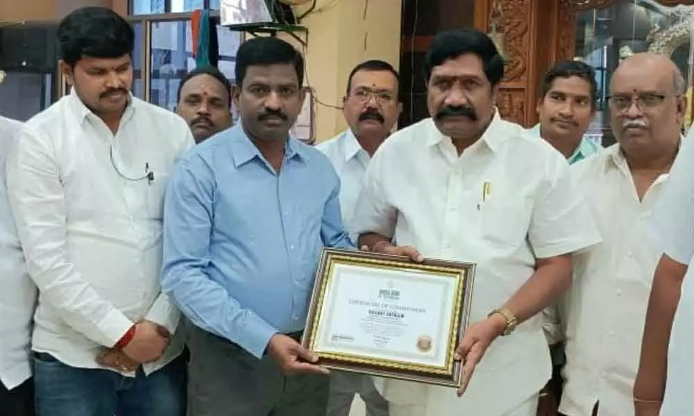 World Book of Records South Region Joint Secretary DR Eliajar presenting the certificate to Vasavi Satram Complex president D Venkateswarulu at a programme in Srisailam on Tuesday