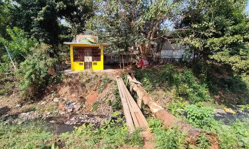 Electric pole being used as bridge to access Juvvalamma temple located in the colony