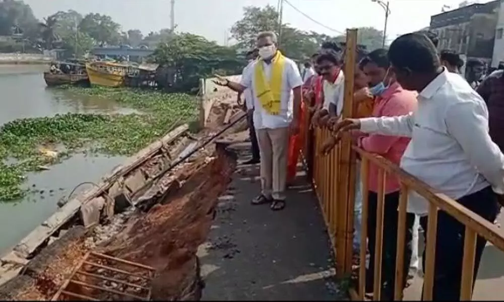 TDP leader Vanamadi Venkateswar Rao and cadres checking the collapsed retaining wall of NTR bridge in Kakinada on Tuesday