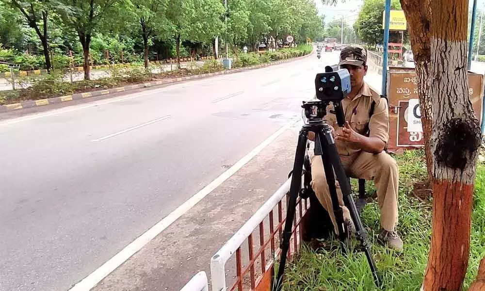 RTA staff monitoring traffic violation through a speed laser gun in Visakhapatnam