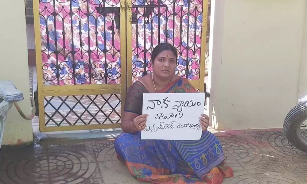 A woman Latha staging a protest in front of her in-laws’ house seeking justice, at Gandhi Nagar in Yemmiganur.