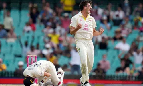Australias Pat Cummins (right) celebrates taking the wicket of Englands Mark Wood (left) during the fifth day of the Ashes Test match in Sydney on Sunday