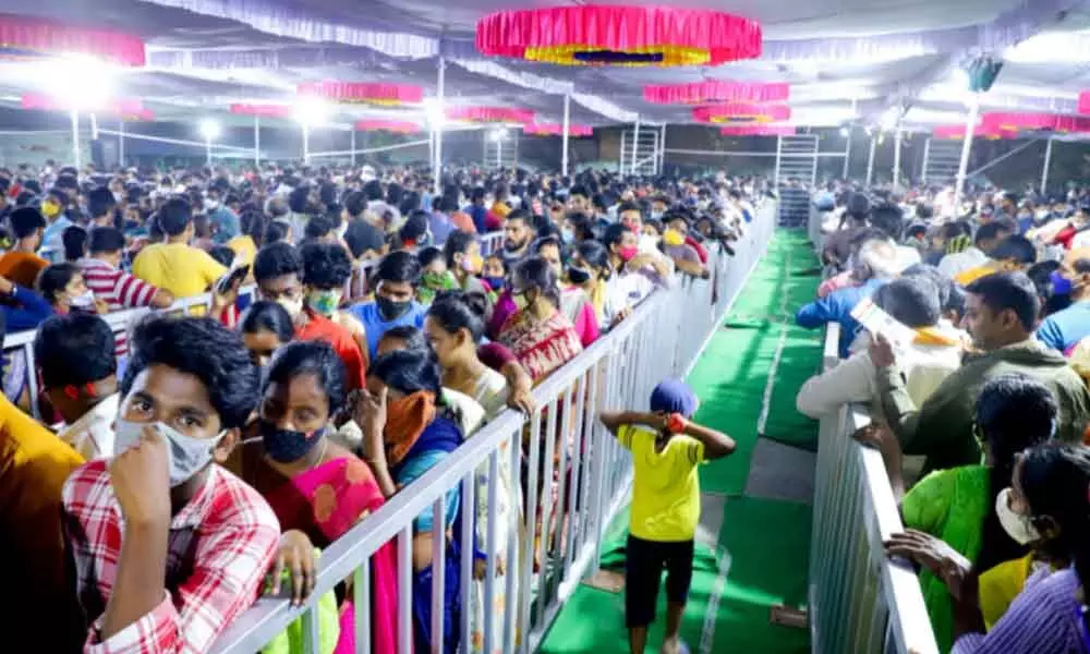 Large number of devotees stand in long queus for Vaikunta Dwara Darshan tickets at Municipal office in Tirupati on Monday