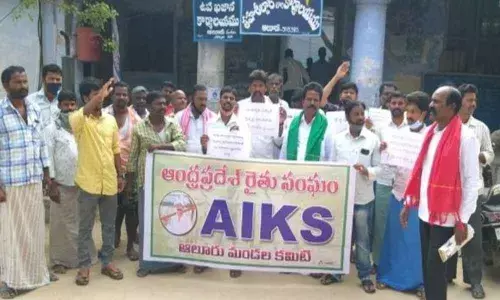 Leaders AIKS staging a protest in front of Mandal Tahsildar office in Kurnool on Monday