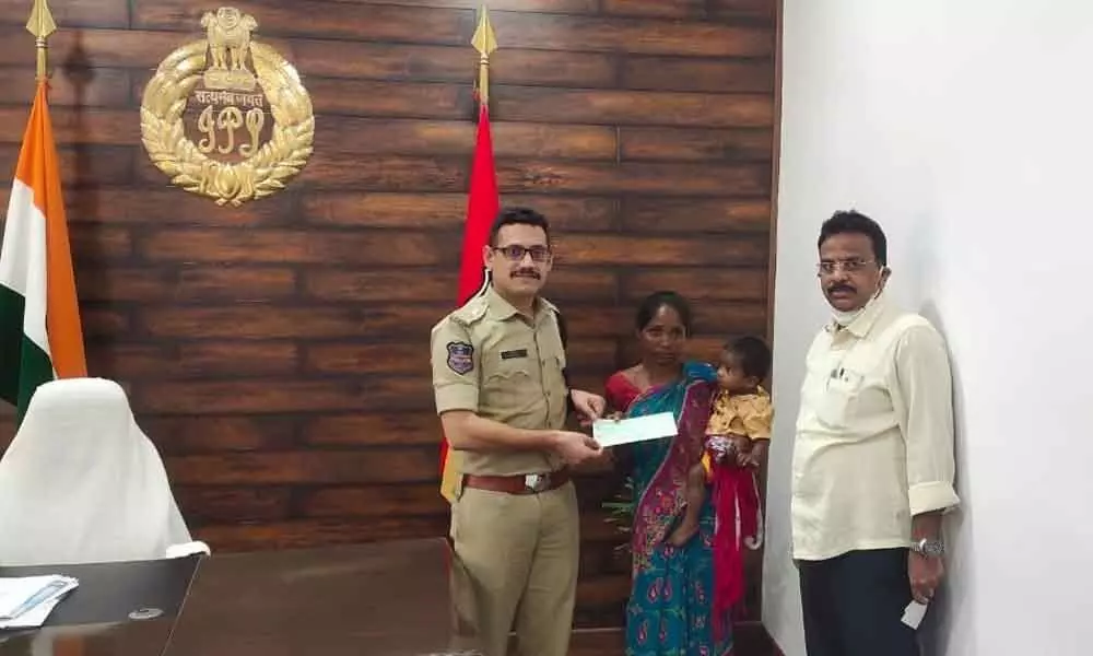 SP Sunil Dutt handing over the financial aid to surrendered Maoists in his office in Kothagudem on Tuesday