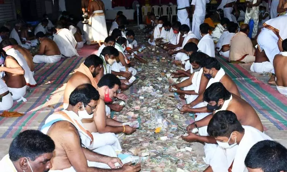 Staff, officials and devotees counting Hundi offerings at Srisailam temple on Tuesday