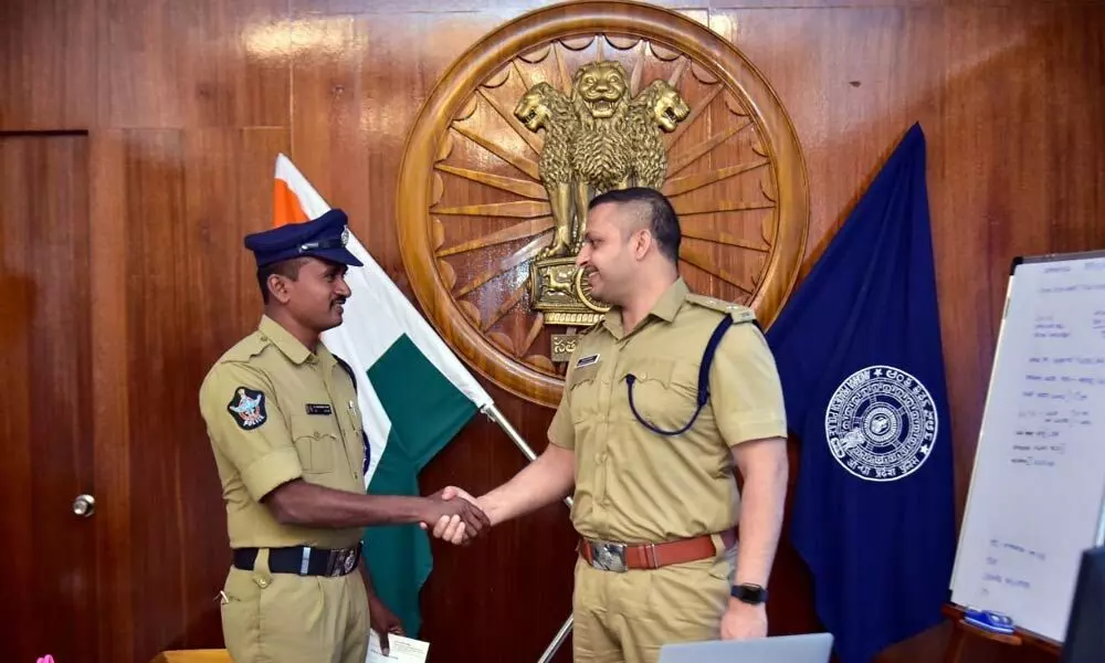 SP Siddharth Kaushal congratulating constable Govind in Machilipatnam on Wednesday