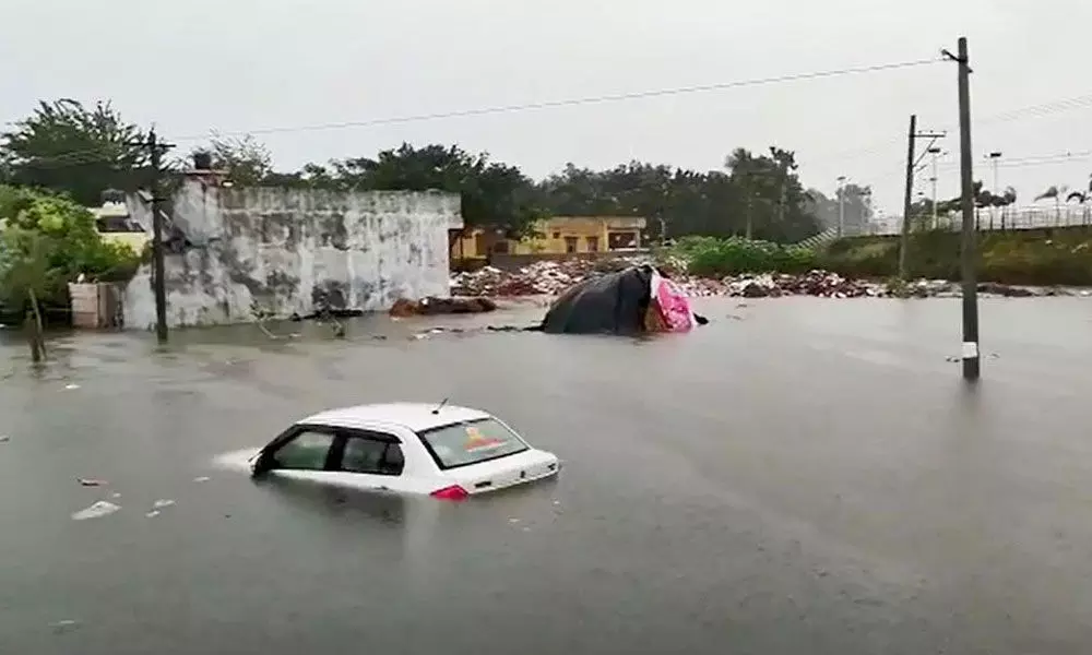 A car stuck in water after heavy rains in Suryapet