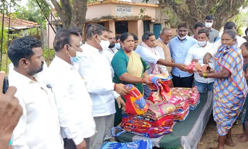 Mulugu MLA Seethakka distributing blankets to women at Dalitwada in Eturnagaram on Sunday