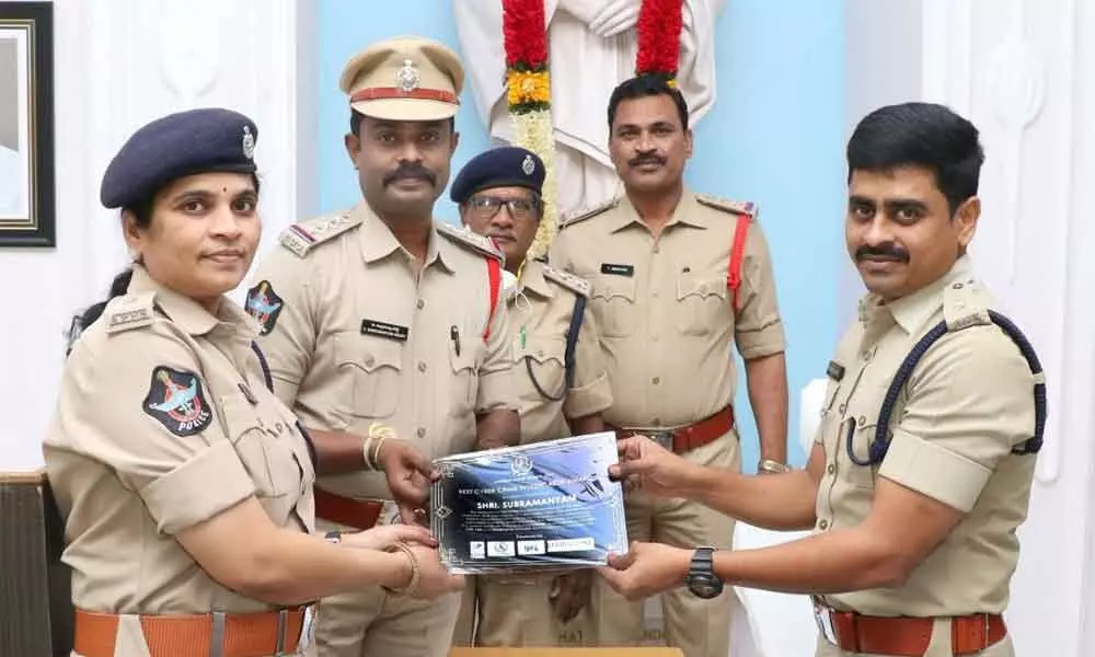 Urban SP Ch V Appala Naidu and Additional SP E Supraja handing over the certificate for best performance to CI V Subramanyam Reddy in Tirupati on Monday