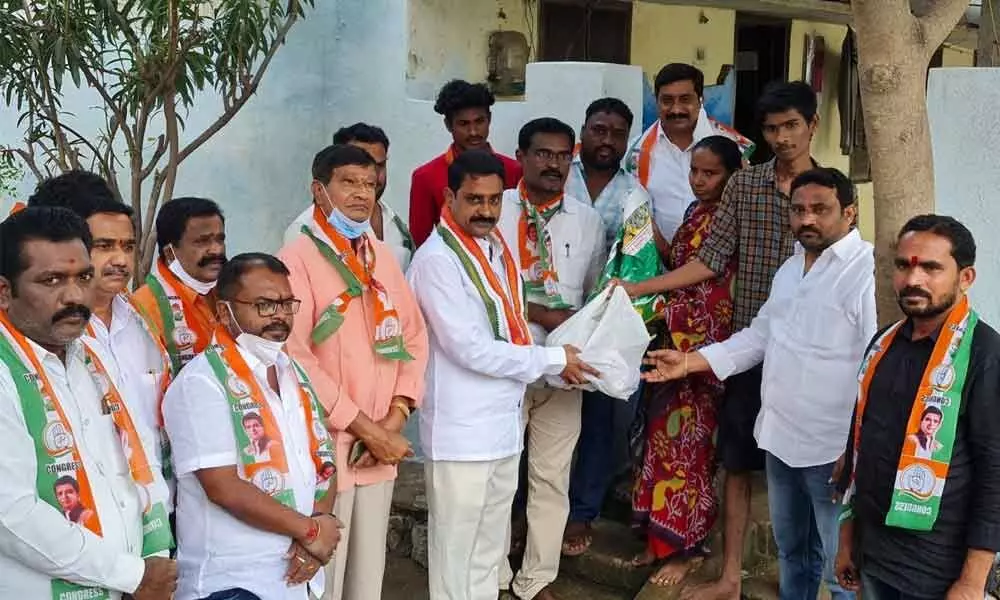 TPCC secretary Patel Ramesh Reddy handing over rice and commodities to families affected by rains in Suryapet on Tuesday