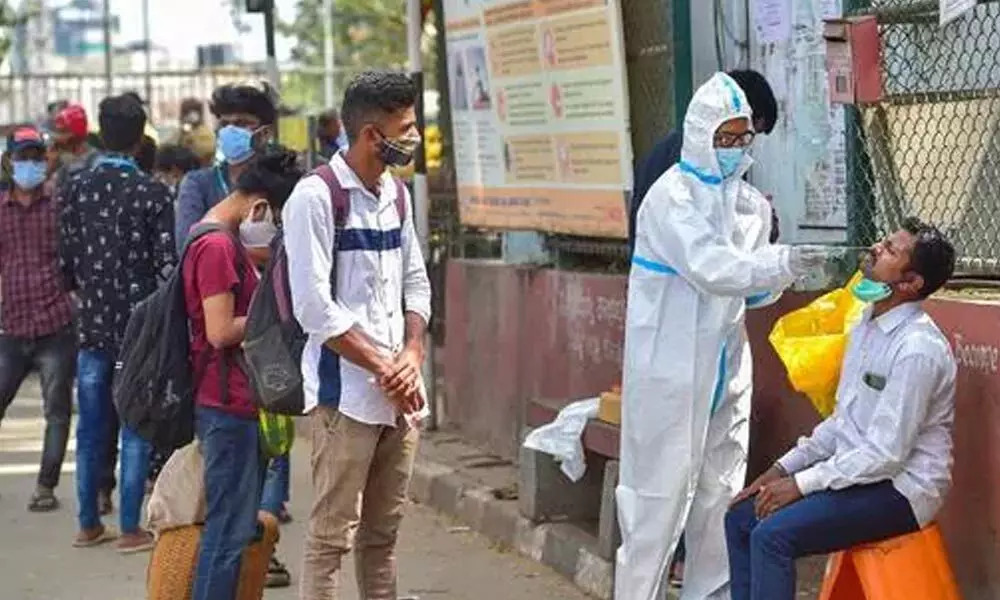 A health worker collects swab sample for Covid-19 test at KSR Railway Station in Bengaluru
