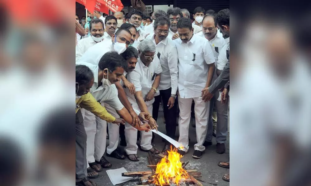 AP NGO State president Bandi Srinivasa Rao and other leaders burn copies of GO on PRC at the NGO Home in Vijayawada on Wednesday.  Photo: Ch Venkata Mastan
