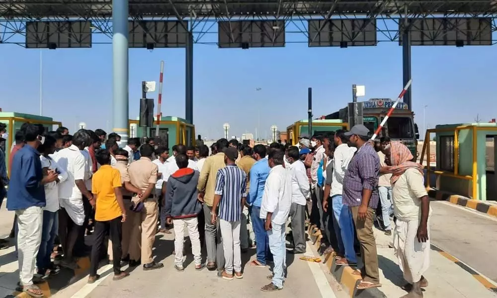 Locals protesting at Dharmaram toll plaza on National Highway 161 in Kamareddy district on Thursday