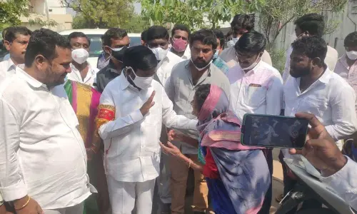 Minister Jagdish Reddy interacting with a woman while distributing Kalyana Lakshmi and Shaadi Mubrak cheques at beneficiaries houses in Suryapet on Thursday