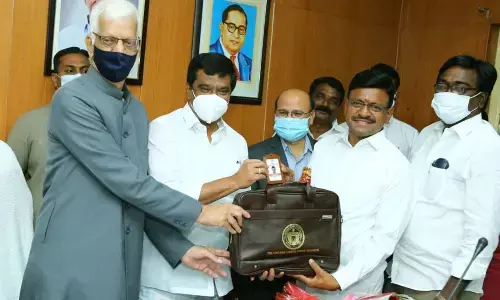 MLC Tata Madhu receiving the identity card from Legislative Council Protem Chairman Syed Aminl Hasan Jaffri and Minister Prasanth Reddy in Hyderabad on Thursday