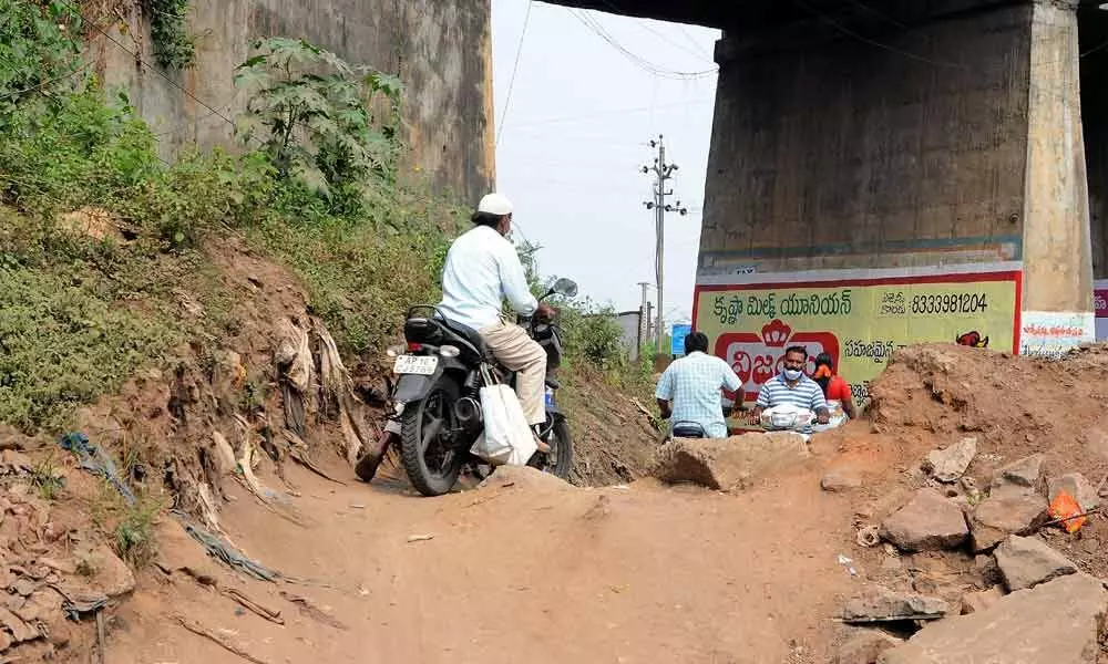 Two-wheeler riders going through the uneven road near Foreman Bungalow Centre