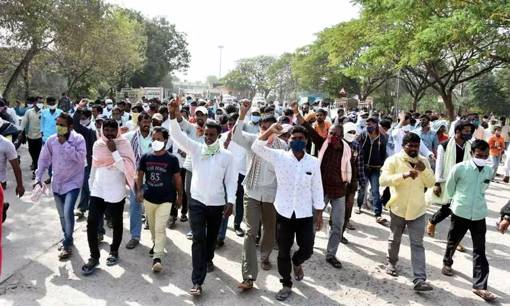Farmers staging protest at Enumamula Agricultural Market Yard in Warangal on Monday