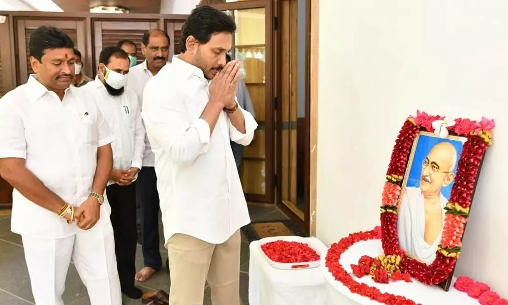 Chief Minister YS Jagan Mohan Reddy paying tributes at his camp office in Tadepalli to Mahatma Gandhi on the occasion of his death anniversary. Endowments Minister Vellampalli Srinivas and others are seen.
