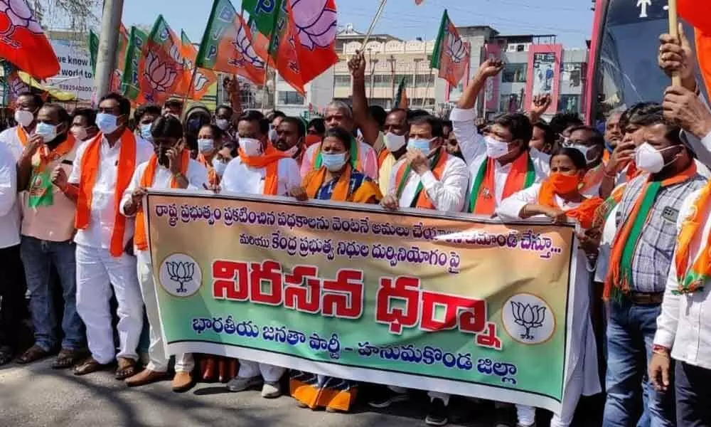 BJP workers staging a protest near Hanumakonda Chowrastha on Monday